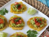Resepti Patacones, kolumbialaisia plantain-paahtoleipiä guacamolen ja tomaattien kera.