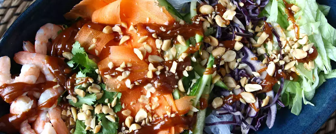 Värikäs salaatti, jossa on riisivermicelliä, katkarapuja ja mausteista maapähkinäkastiketta.