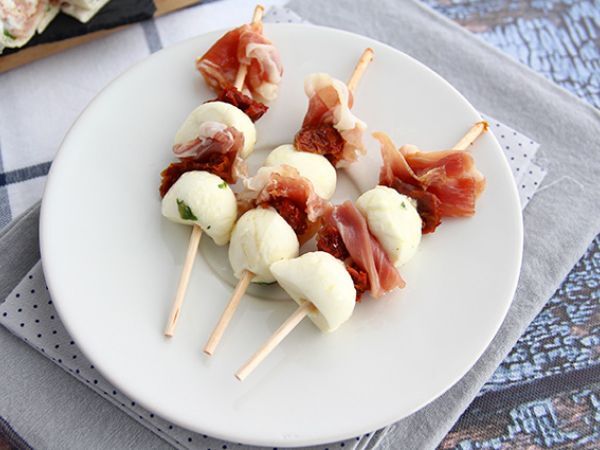 Resepti Mozzarellapalloja, suolakinkkua ja aurinkokuivattuja tomaatteja sisältävät aperitiivivartaat.