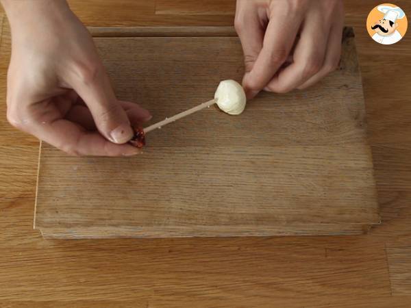 Mozzarellapalloja, suolakinkkua ja aurinkokuivattuja tomaatteja sisältävät aperitiivivartaat. - Valmistelu askel 2