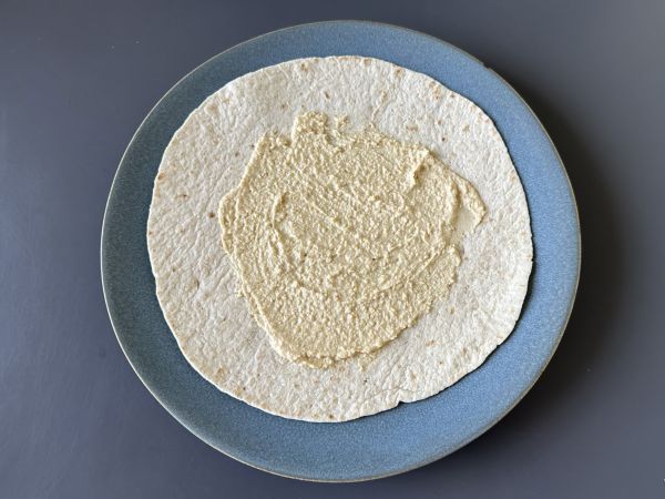Välimerellinen wrap täytetty hummuksella, rucolalla, paprikoilla ja fetalla. - Valmistelu askel 2