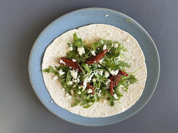 Välimerellinen wrap täytetty hummuksella, rucolalla, paprikoilla ja fetalla. - Valmistelu askel 3