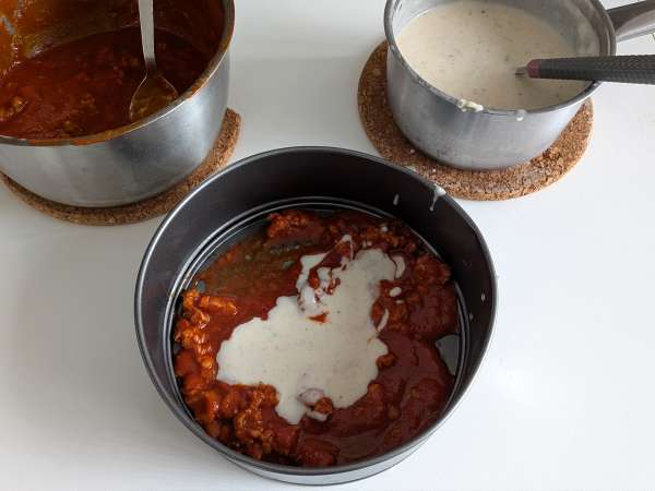 Uunissa paistettu rigatoni-timballo, jossa on makkaraa, besciamellaa ja mozzarellaa - Valmistelu askel 7