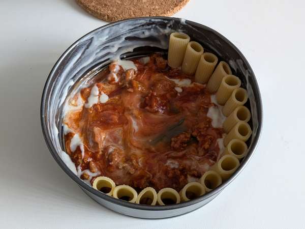Uunissa paistettu rigatoni-timballo, jossa on makkaraa, besciamellaa ja mozzarellaa - Valmistelu askel 8