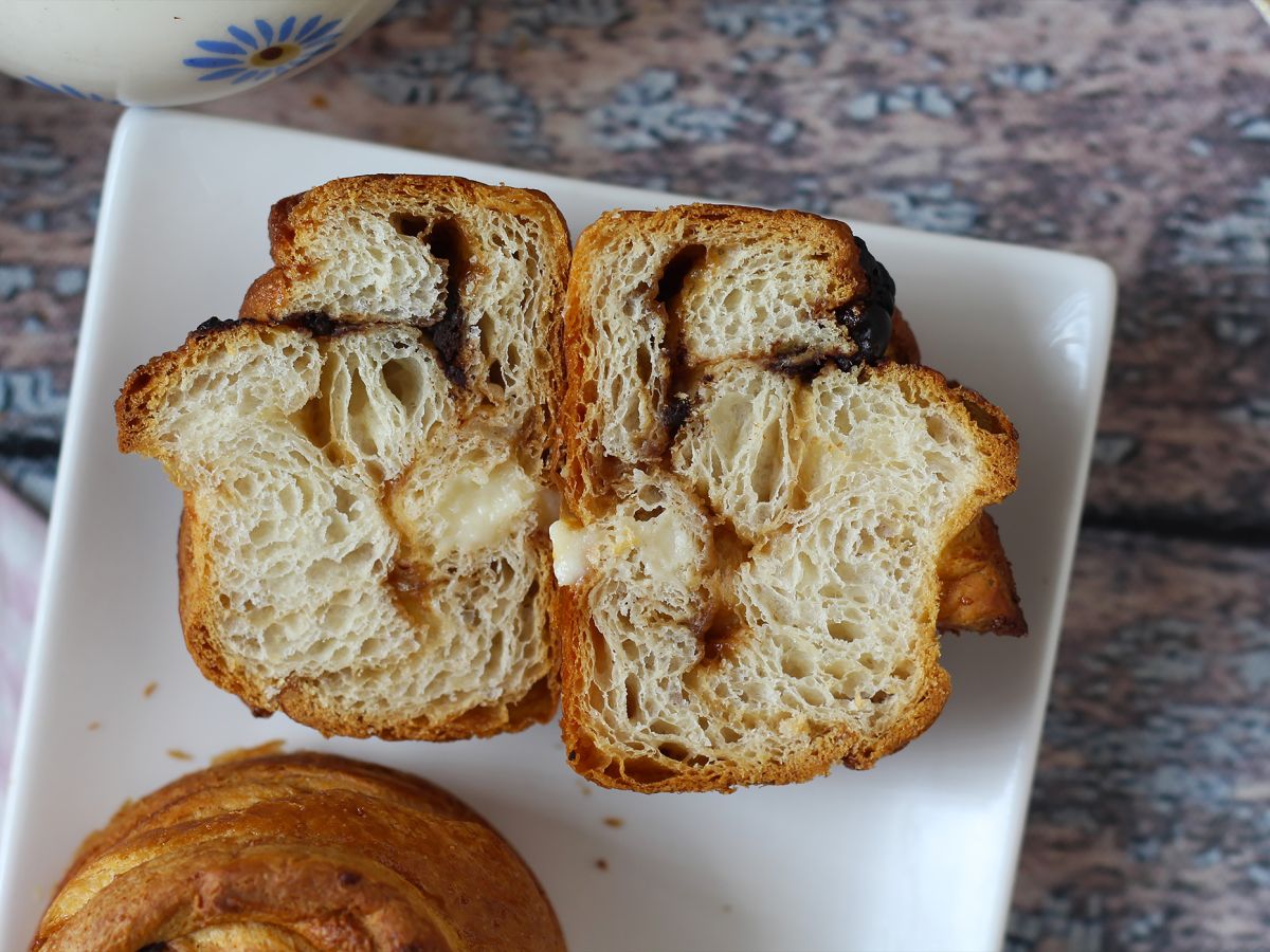 Cruffins, croissantin ja muffinssin yhdistelmä, jossa on vaniljakastiketta ja suklaata. - kuva 2