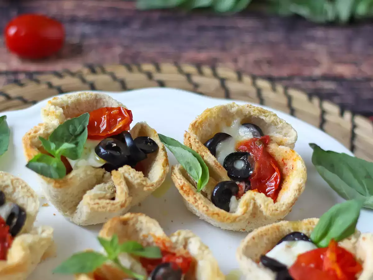 Leipäkorit, joissa on mozzarellaa, kirsikkatomaatteja ja mustia oliiveja.