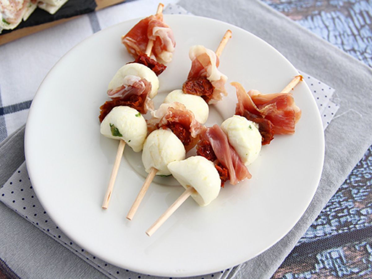 Mozzarellapalloja, suolakinkkua ja aurinkokuivattuja tomaatteja sisältävät aperitiivivartaat.