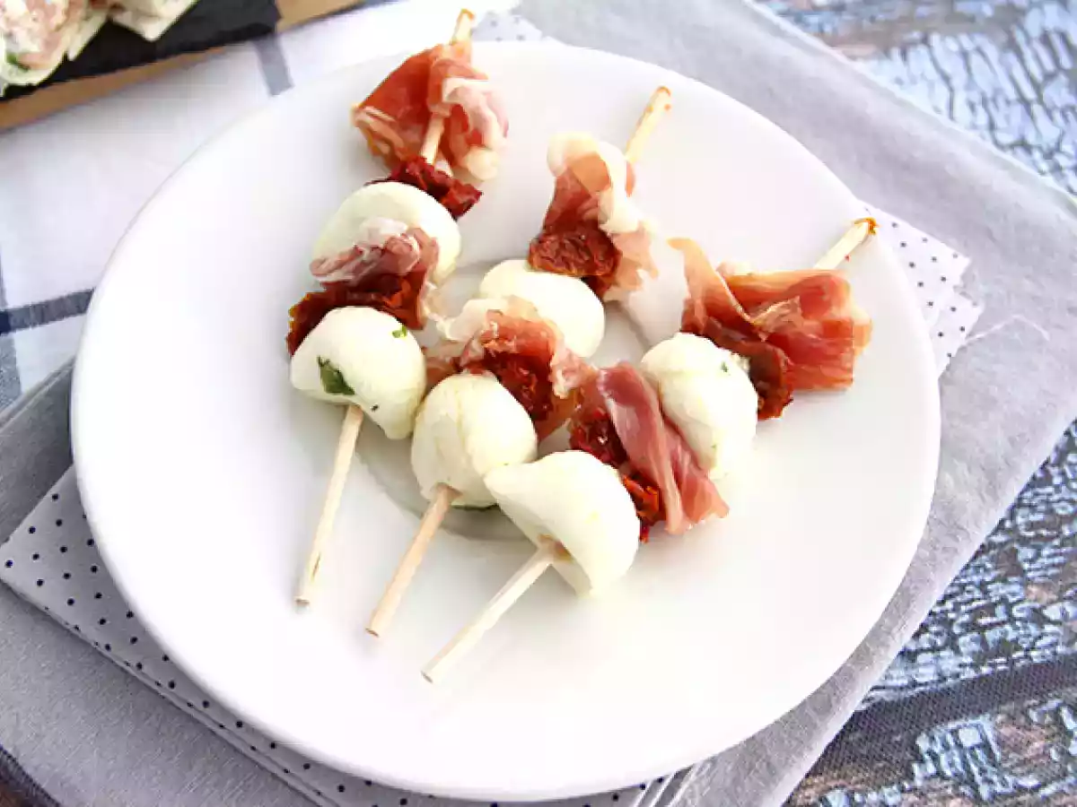 Mozzarellapalloja, suolakinkkua ja aurinkokuivattuja tomaatteja sisältävät aperitiivivartaat.