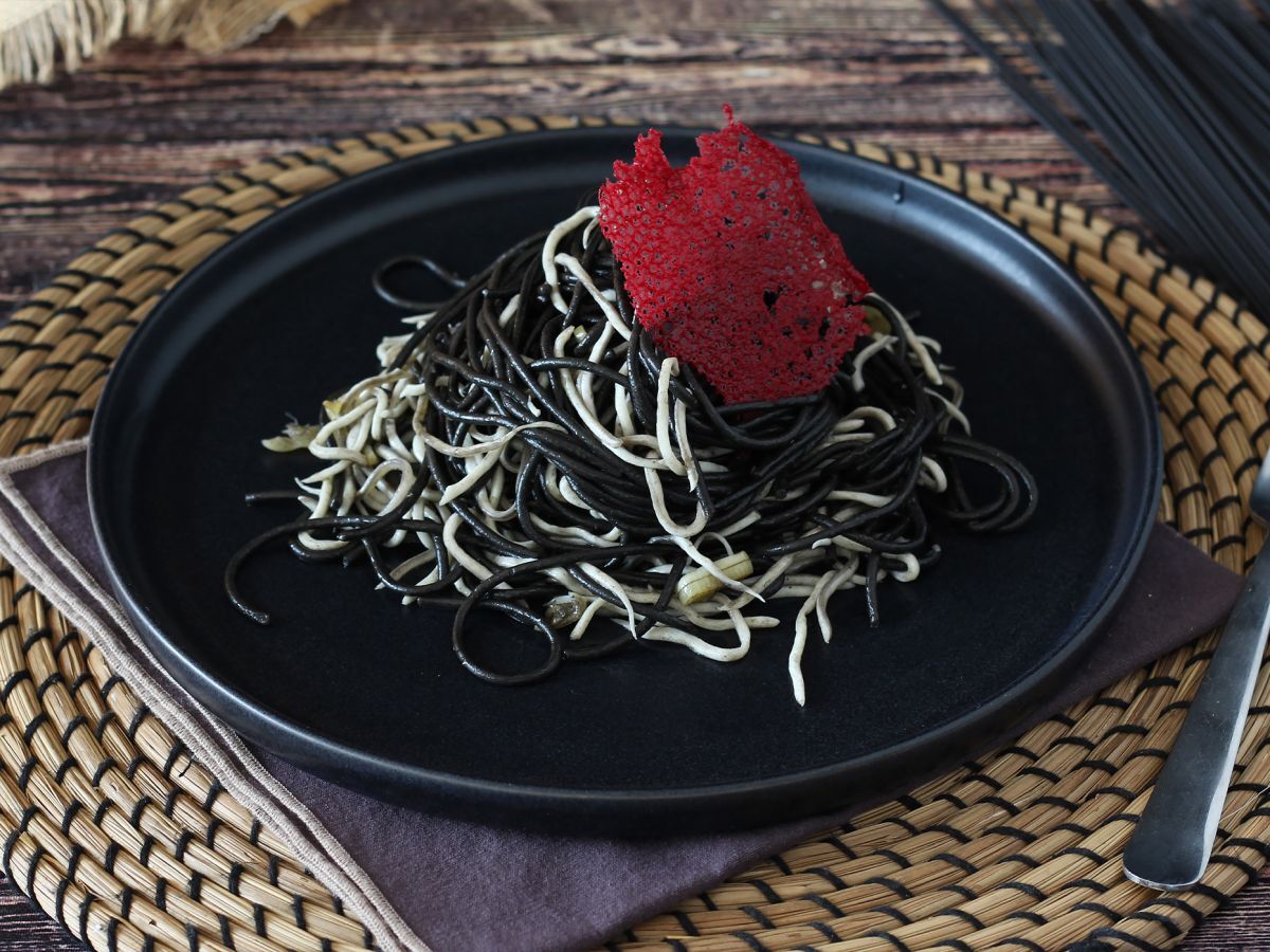 Mustat spagetit valkosipulin ja gulasin kera. Pasta al nero di seppia