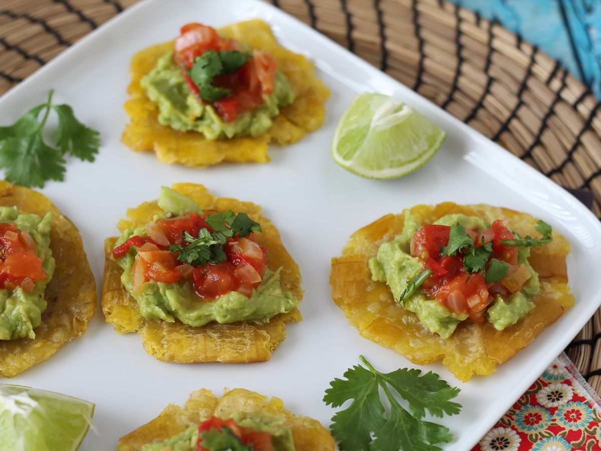 Patacones, kolumbialaisia plantain-paahtoleipiä guacamolen ja tomaattien kera.
